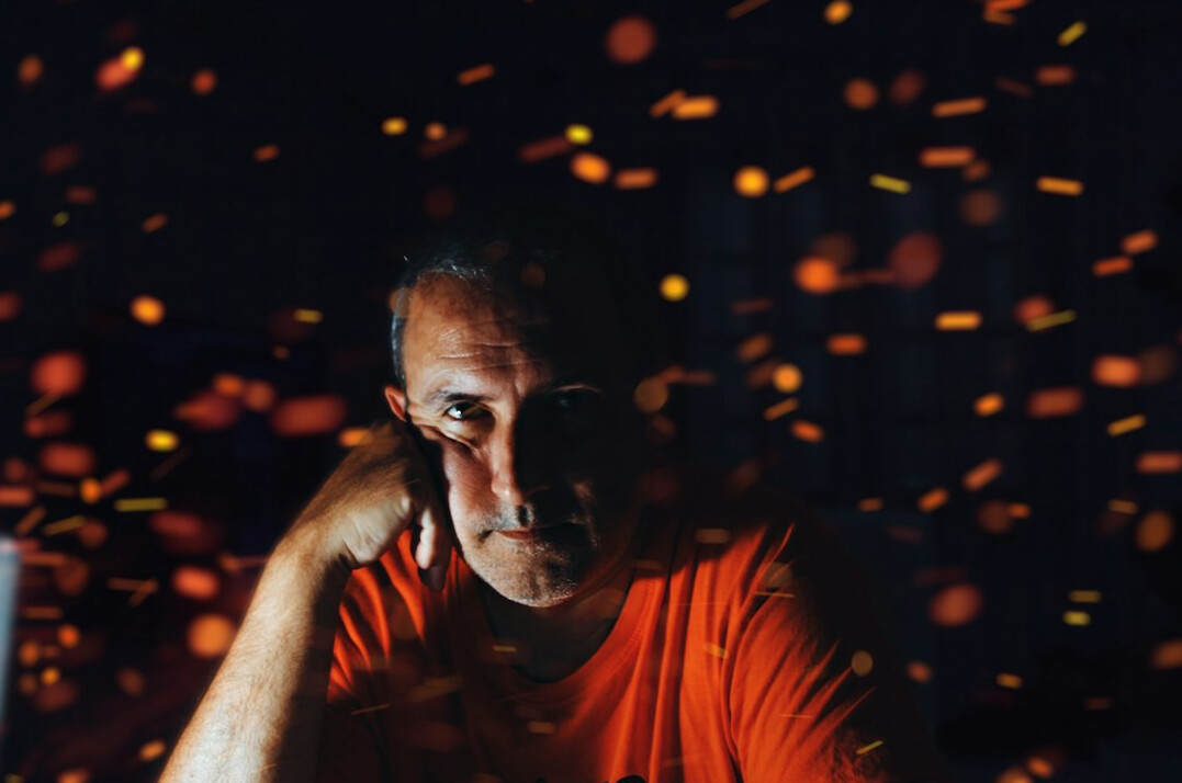 Man looking thoughtfully at a screen full of code