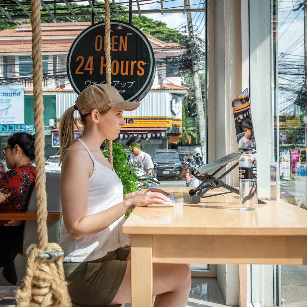 woman coding on laptop at cafe
